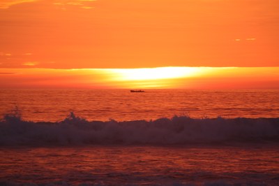 sunset fishing boat and crashing waves.JPG