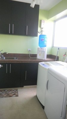   Bright Laundry Room With Washer, Dryer, And Deep Sink 